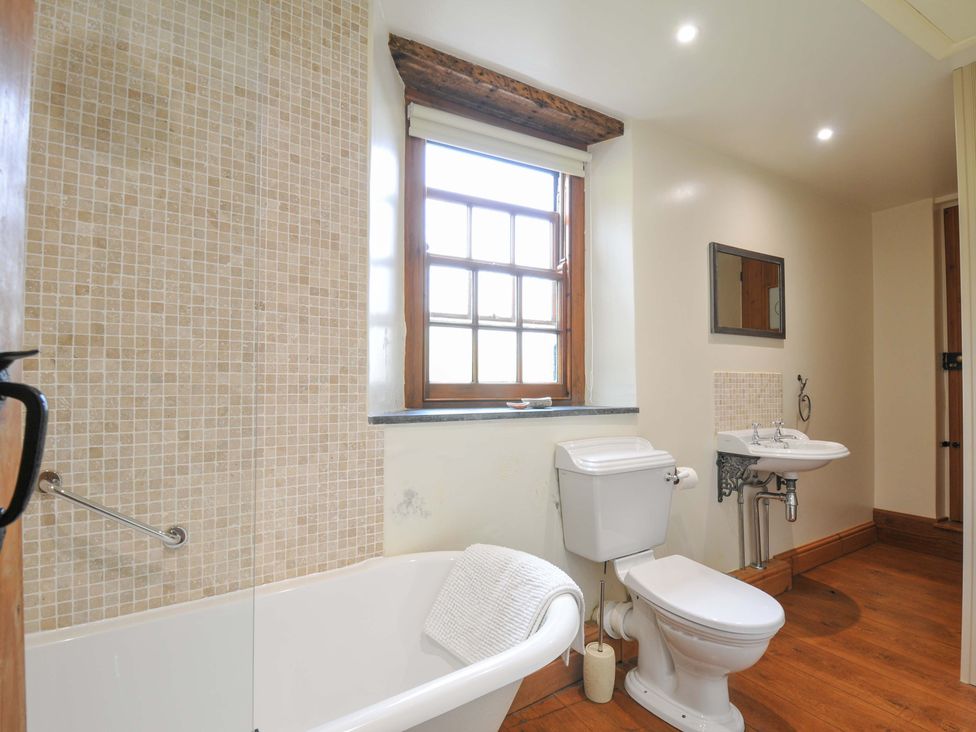 A bathroom with a bathtub, toilet, and sink at Jolly Crabber in Porthpean near St Austell