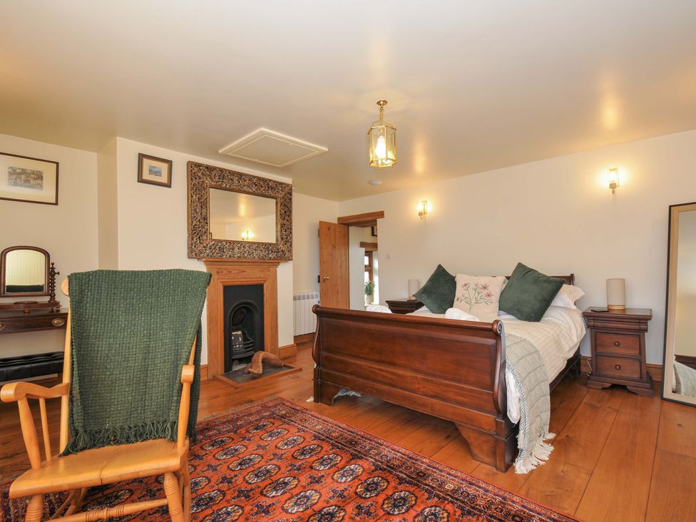 A bedroom with a bed and a rocking chair at Jolly Crabber in Porthpean near St Austell