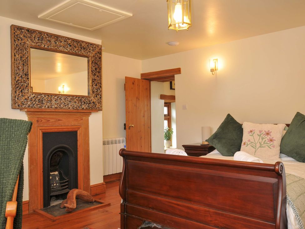 A bedroom with a bed and mirror at Jolly Crabber in Porthpean near St Austell