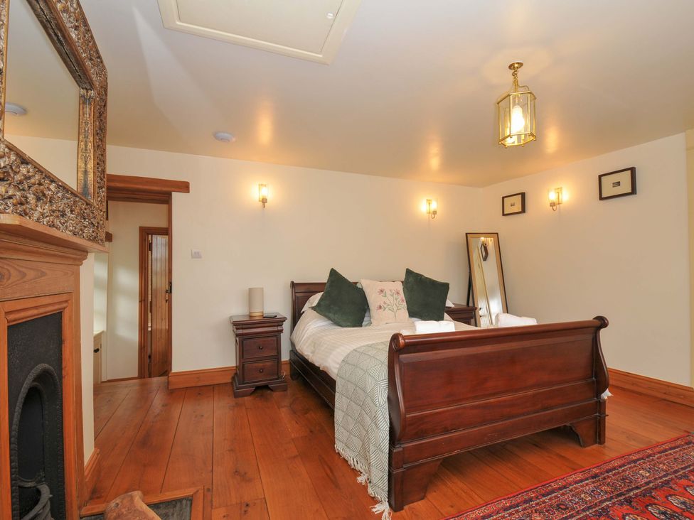 A bedroom with a bed and nightstand at Jolly Crabber in Porthpean near St Austell