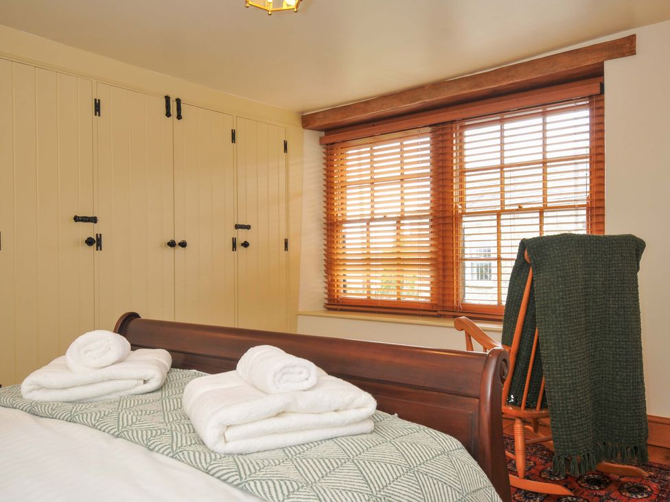 A bedroom featuring a bed with towels and a window at Jolly Crabber in Porthpean near St Austell