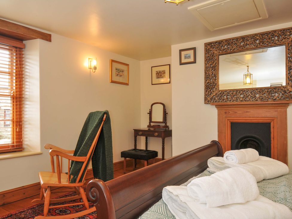 A bedroom with a rocking chair and bed at Jolly Crabber in Porthpean near St Austell