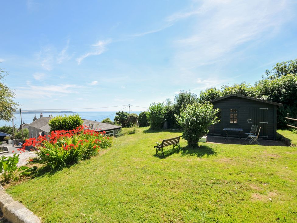 A garden with a shed and a bench at Jolly Crabber in Porthpean near St Austell