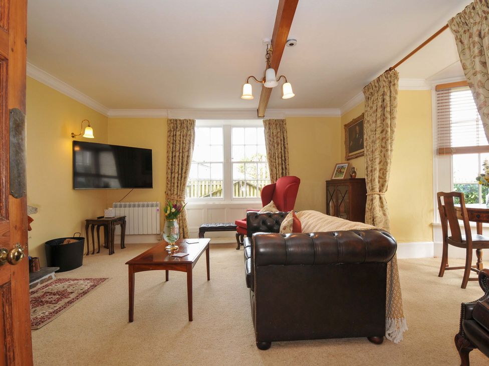A living room with a sofa and armchair at Smugglers in Porthpean near St Austell