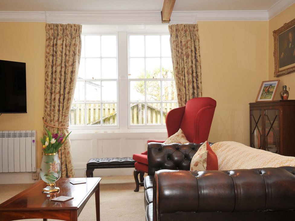 A living room with a sofa and armchair at Smugglers in Porthpean near St Austell