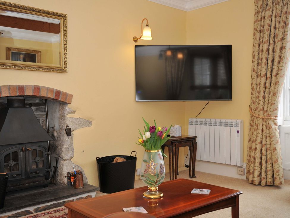 A living room with a fireplace and television at Smugglers in Porthpean near St Austell