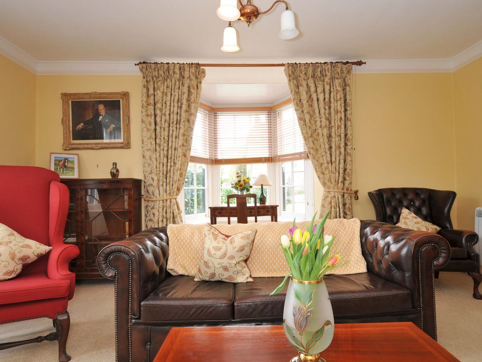 A living room with a sofa and armchair at Smugglers in Porthpean near St Austell