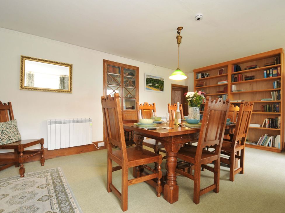 A dining room with a table and chairs at Smugglers Porthpean near St Austell