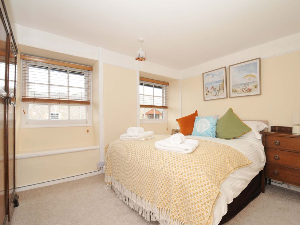 A bedroom with a bed and artwork at Smugglers in Porthpean near St Austell