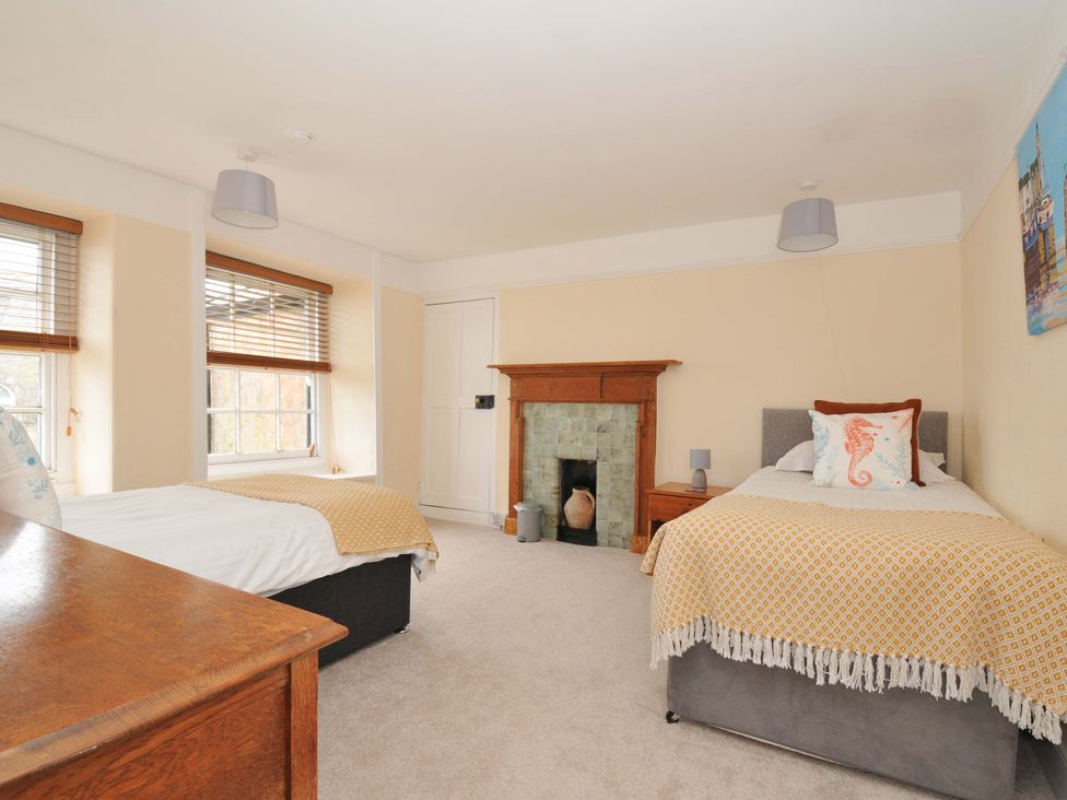 A bedroom with two beds and a fireplace at Smugglers in Porthpean near St Austell