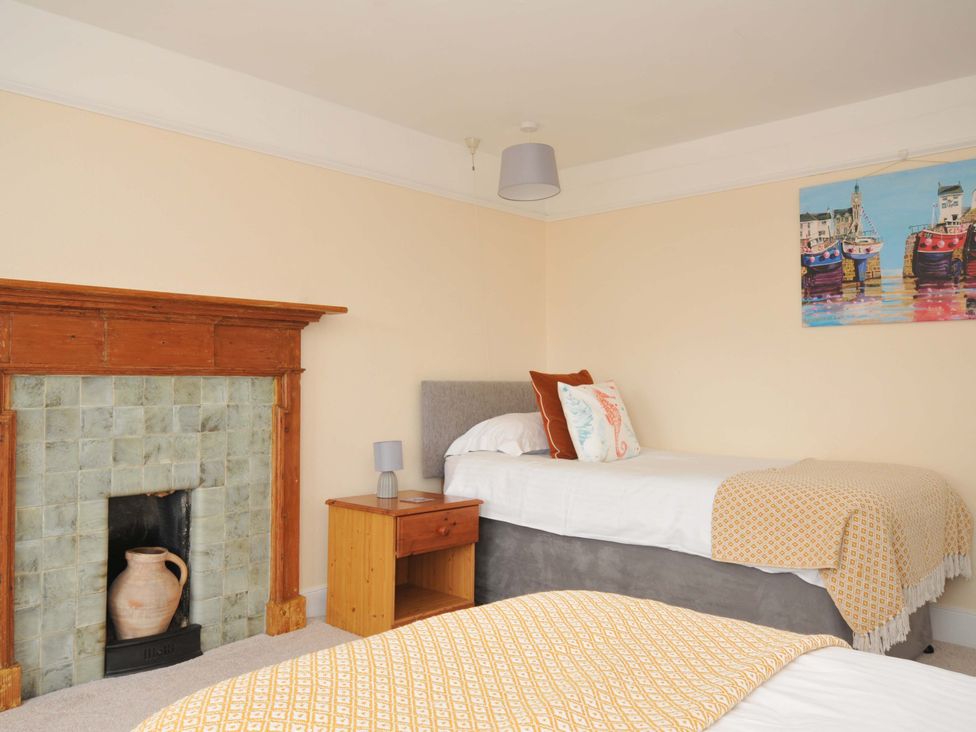 A bedroom with beds and a nightstand at Smugglers in Porthpean near St Austell