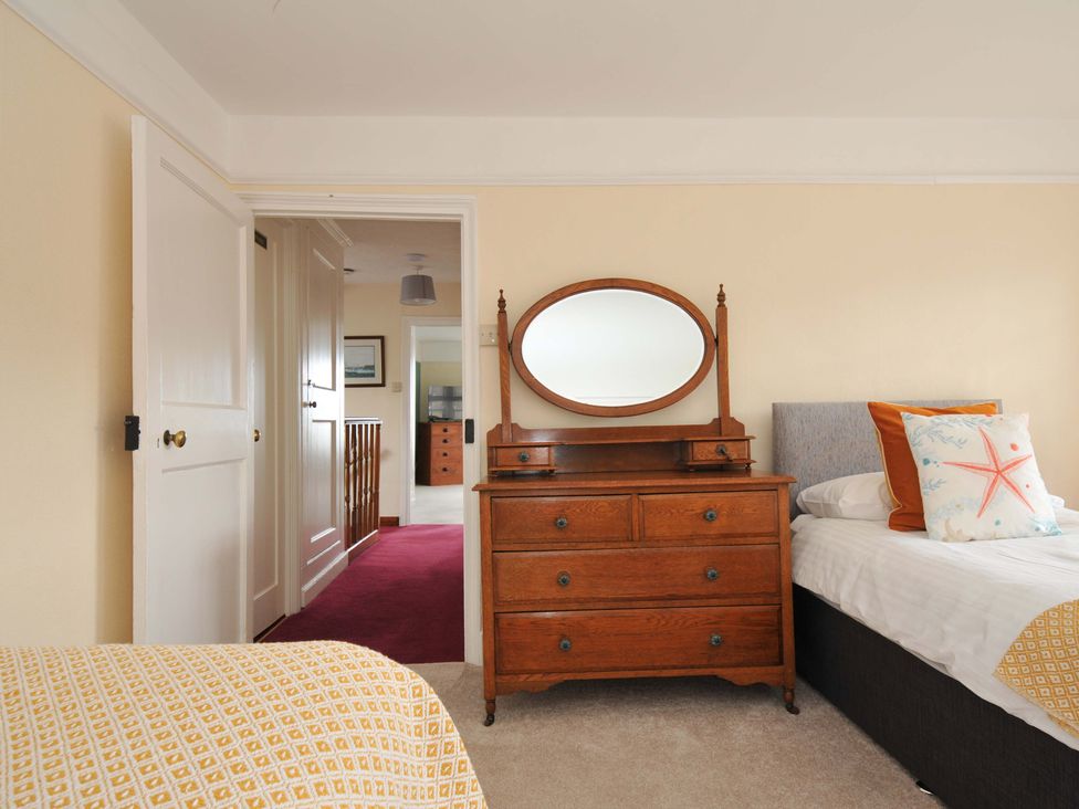 A bedroom with a dresser and a bed at Smugglers in Porthpean near St Austell