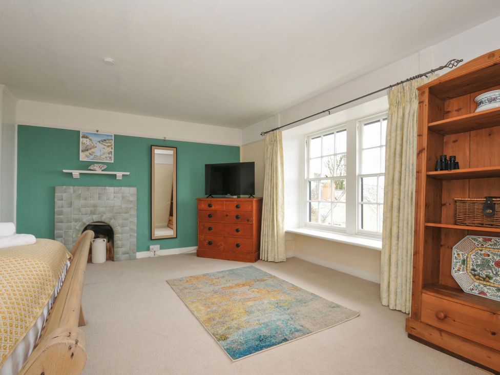 A bedroom with a bed, television, and dresser at Smugglers in Porthpean near St Austell