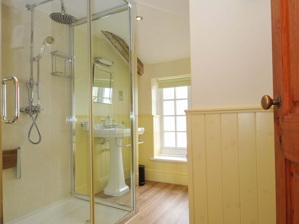 A bathroom with a shower and wash basin at Smugglers in Porthpean near St Austell