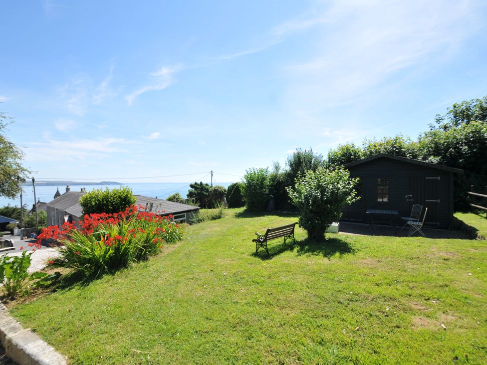 A garden with a shed and bench at Smugglers in Porthpean near St Austell