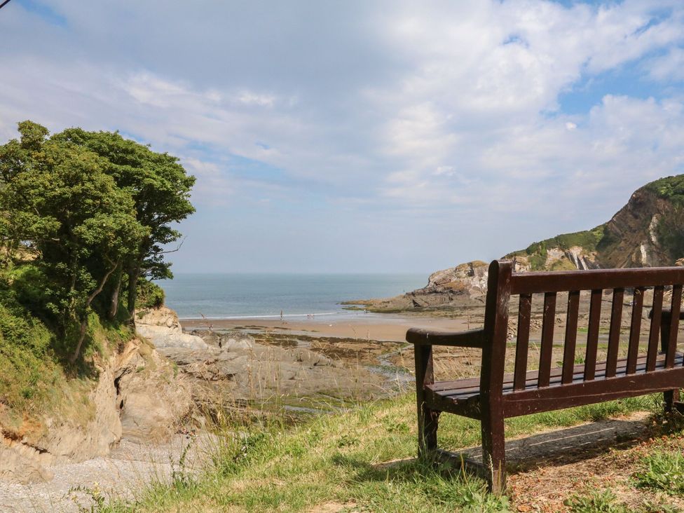 A view of the beach and sea with a bench at Watermouth Castle, Penn-Curzon Apartment, Berrynarbor near Ilfracombe