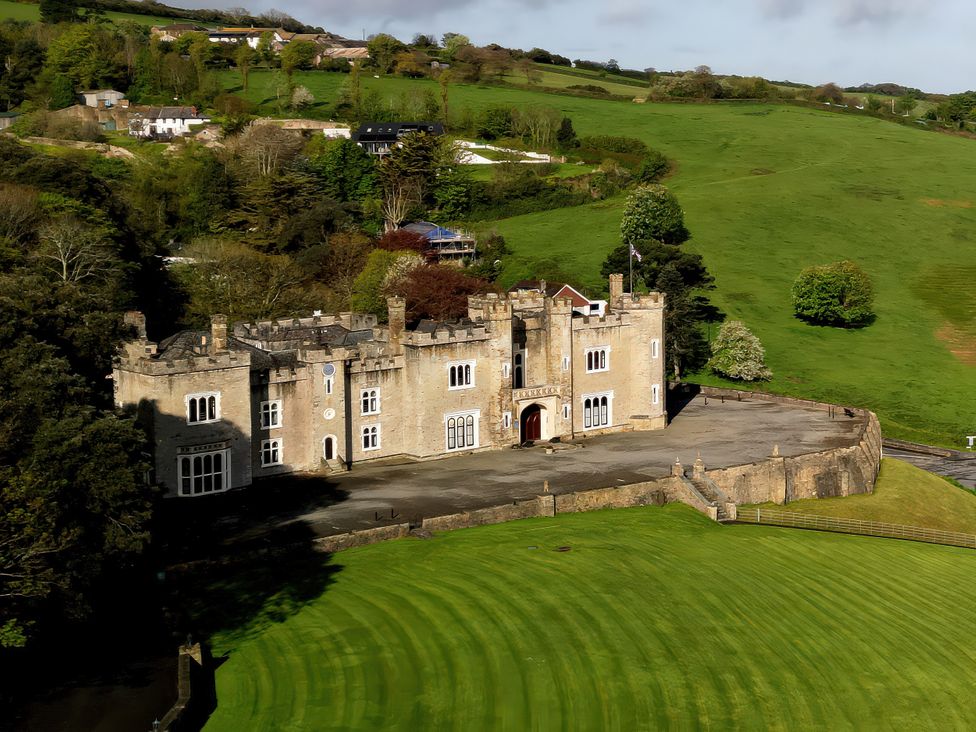 An aerial view of a castle surrounded by green fields at Watermouth Castle, Bassett Apartment in Berrynarbor near Ilfracombe