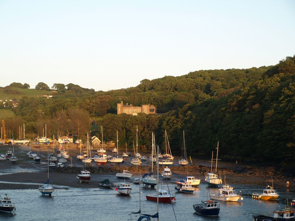 A view of boats on the water with trees and a building at Watermouth Castle, Bassett Apartment in Berrynarbor near Ilfracombe