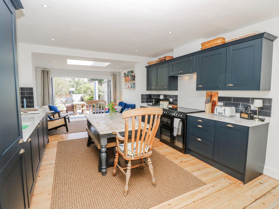 A kitchen with a dining table and appliances at 4 Copse Lane Freshwater
