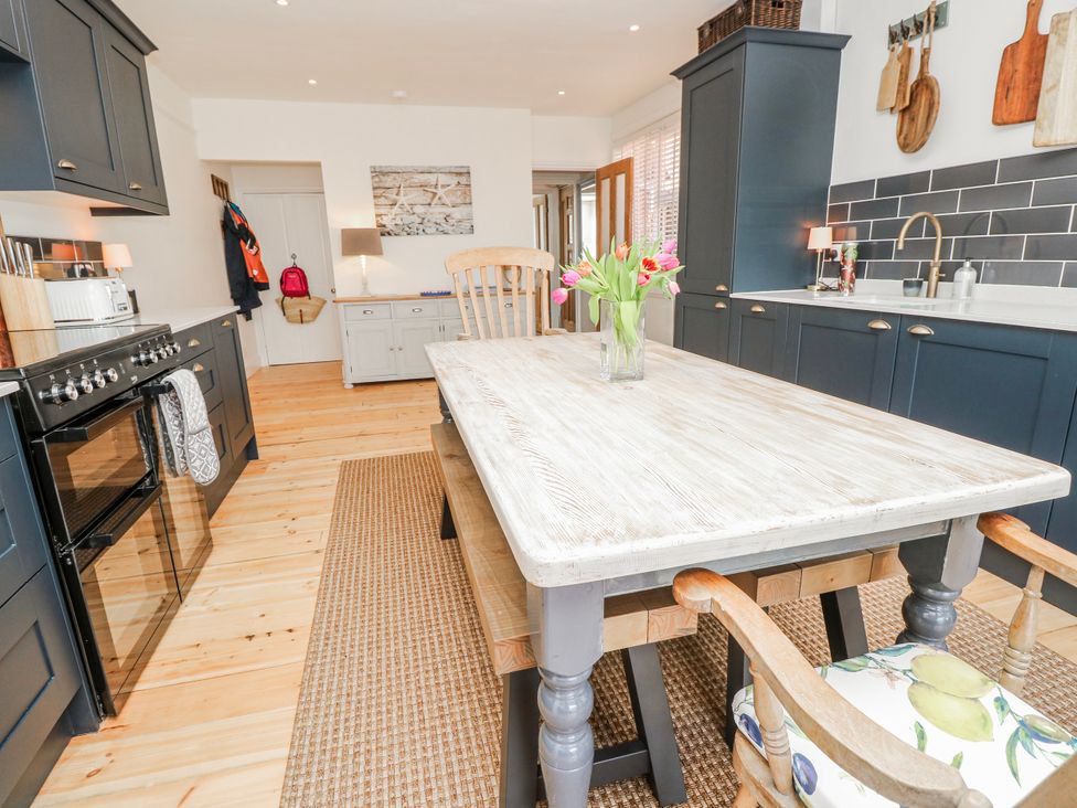 A kitchen with a table and chairs at 4 Copse Lane in Freshwater