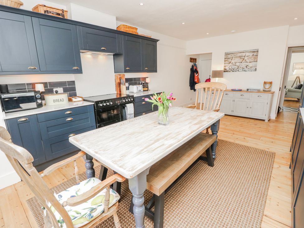 A kitchen with cabinets and a table at 4 Copse Lane Freshwater