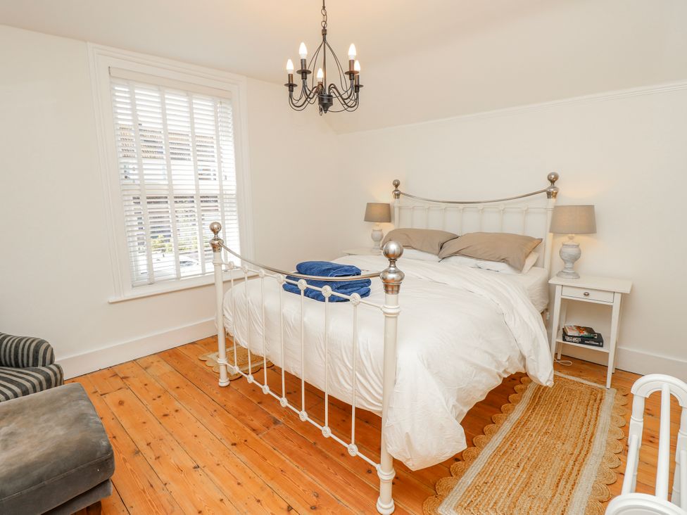A bedroom with a bed and bedside table at 4 Copse Lane in Freshwater