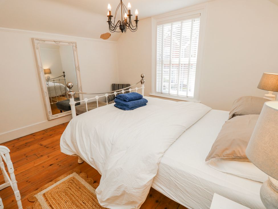 A bedroom with a bed and mirror at 4 Copse Lane Freshwater