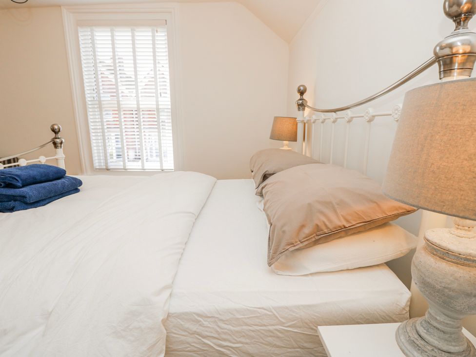 A bedroom with a bed and lamp at 4 Copse Lane Freshwater