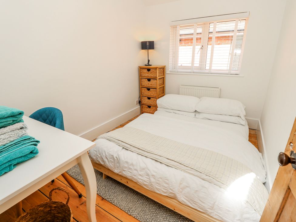 A bedroom with a bed and a table at 4 Copse Lane Freshwater