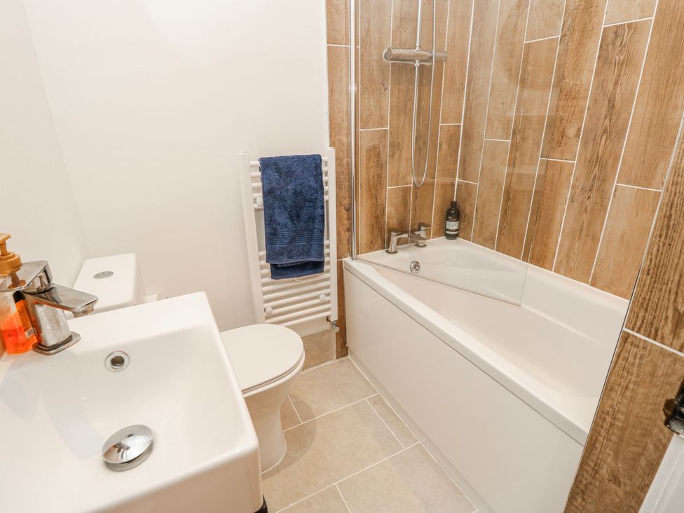 A bathroom with a bathtub, toilet, and sink at 4 Copse Lane in Freshwater