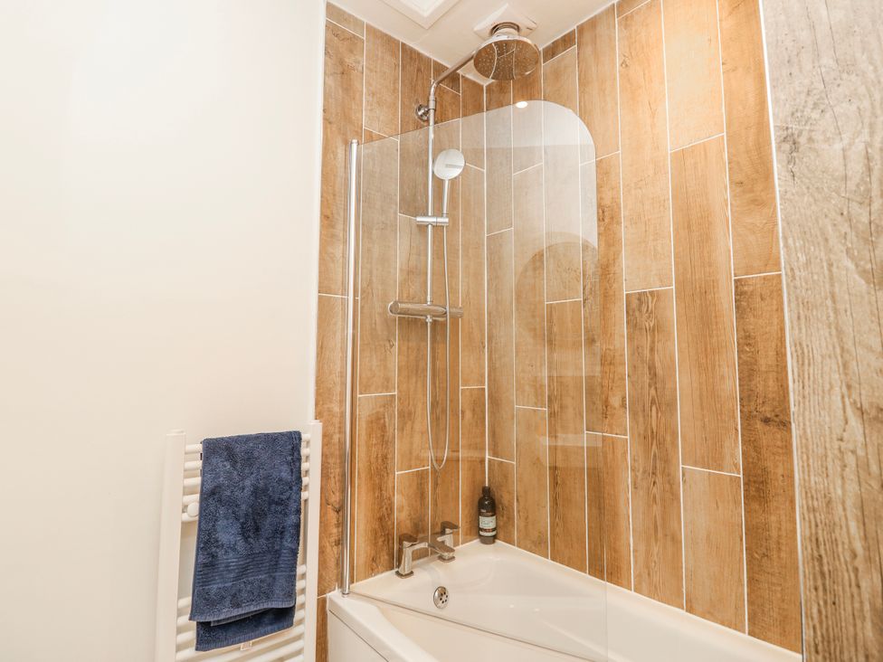 A bathroom with a shower over a bathtub at 4 Copse Lane Freshwater