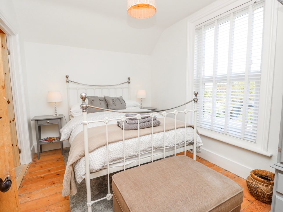 A bedroom with a bed and bedside table at 4 Copse Lane in Freshwater