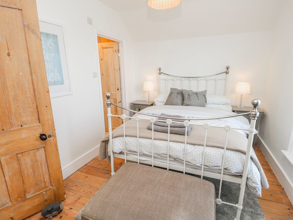 A bedroom with a white bed and bedside tables at 4 Copse Lane in Freshwater
