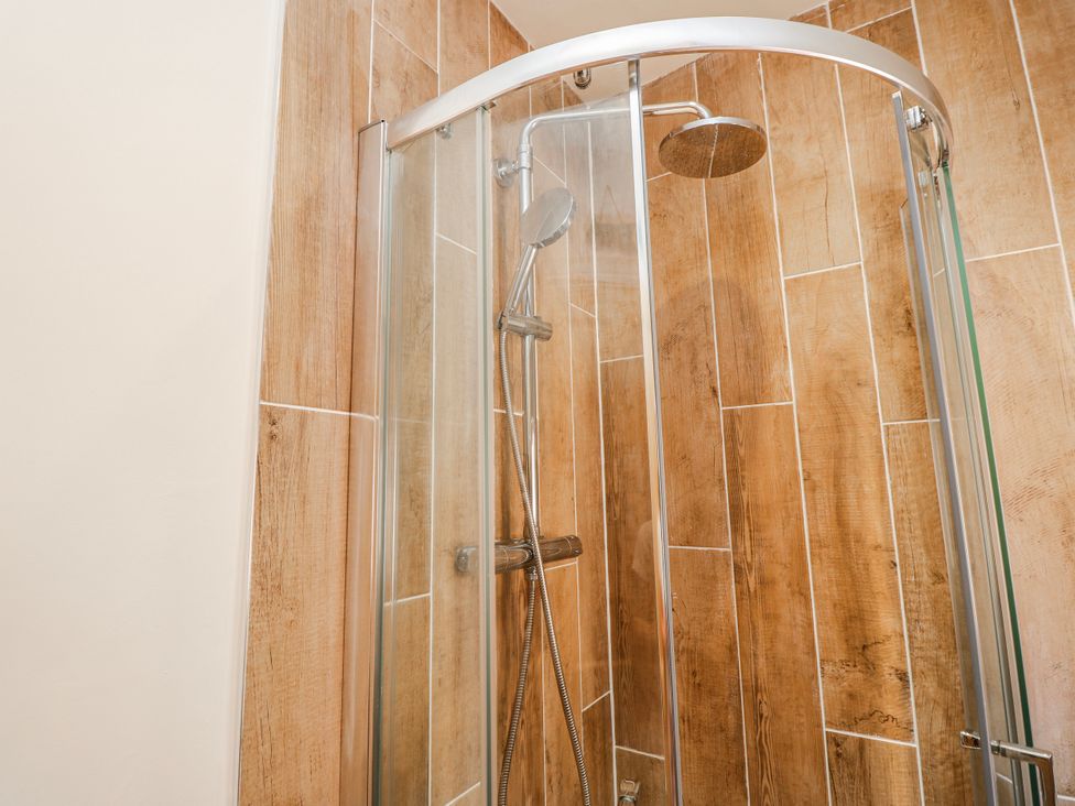 A shower with glass door and tile wall at 4 Copse Lane in Freshwater