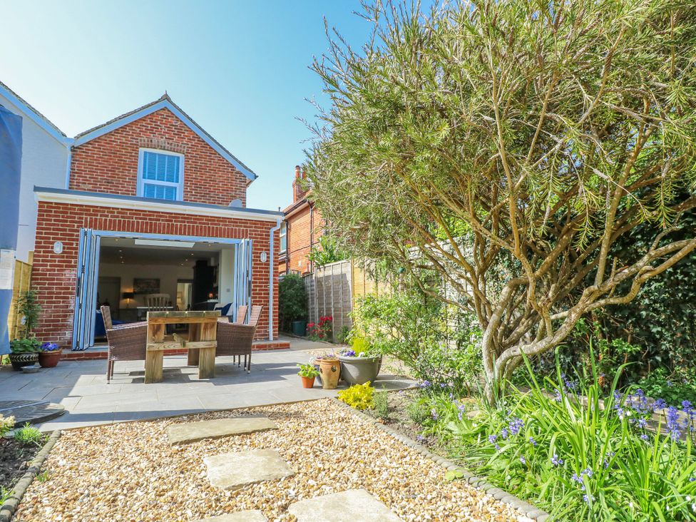 A garden with a dining table and chairs at 4 Copse Lane in Freshwater