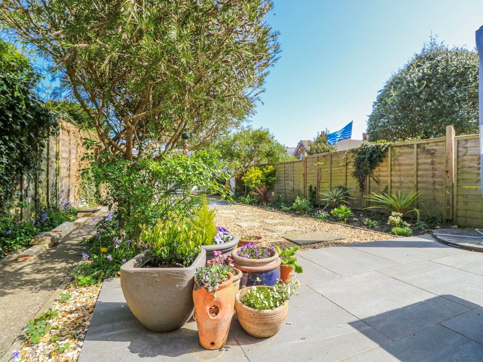 A garden with flower pots and a pathway at 4 Copse Lane Freshwater