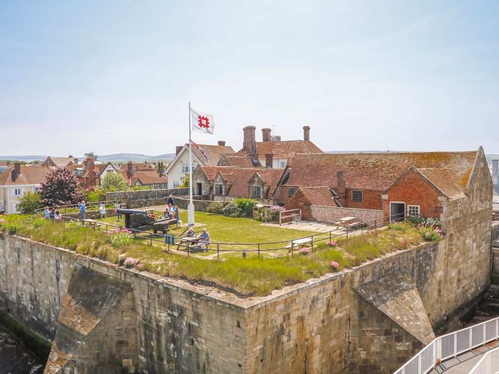 An outdoor area with a grass lawn and buildings at 4 Copse Lane in Freshwater