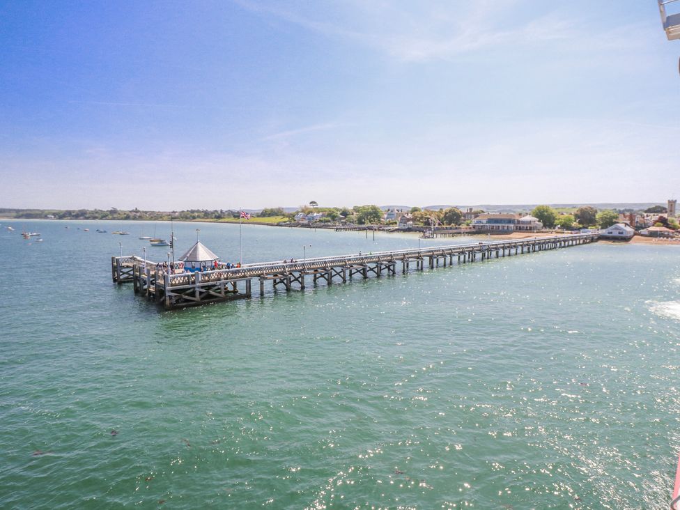 A pier extending into the water with boats nearby at 4 Copse Lane Freshwater