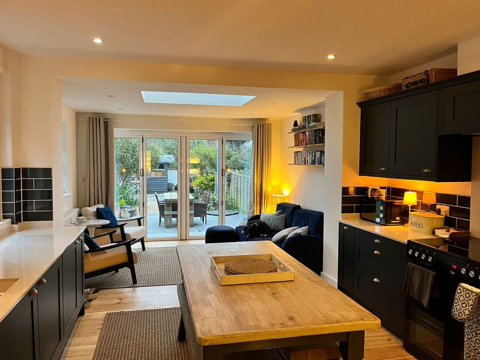 A kitchen with a dining table and sliding doors leading to a garden at 4 Copse Lane in Freshwater