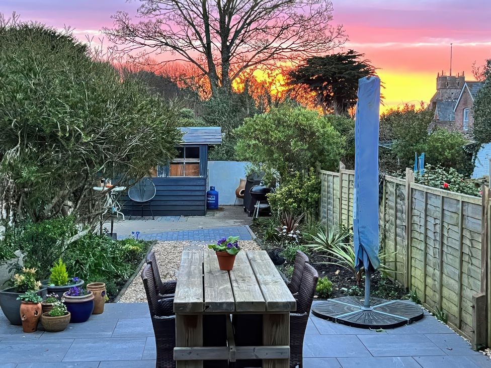 A garden with a table and chairs at 4 Copse Lane in Freshwater
