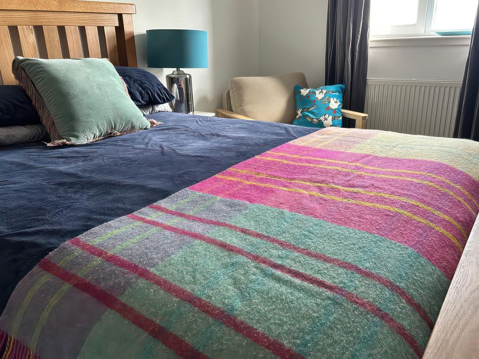 A bedroom with a bed and lamp at Duart At The Sea Auckengill John O Groats