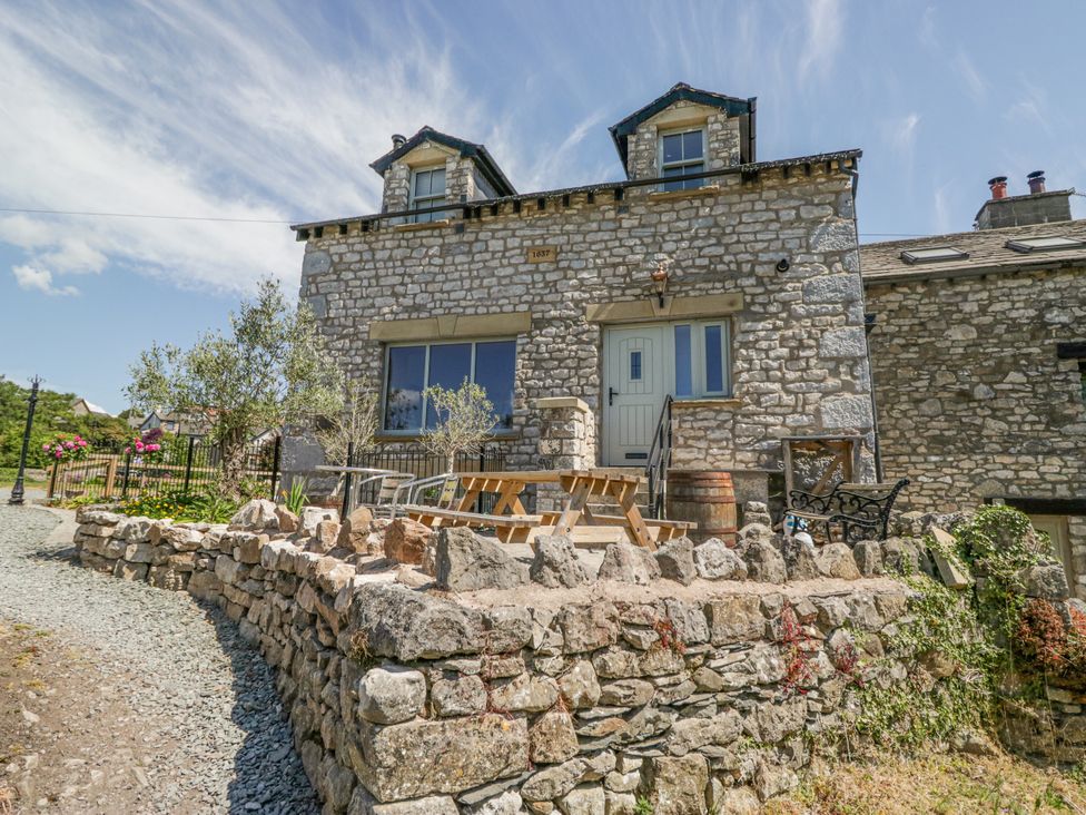 A house with stone walls and patio furniture at Old Watermill in Cartmel
