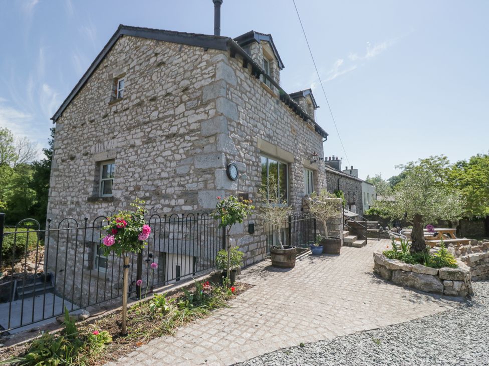A stone house with a garden at The Old Watermill in Cartmel