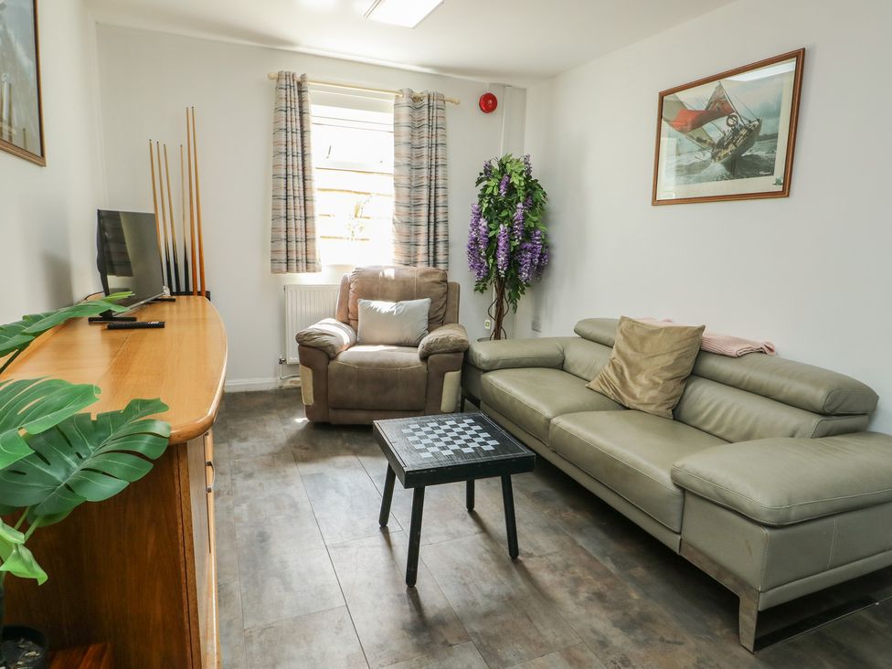 A living room with a sofa, armchair, and coffee table at The Bevan in Bontnewydd, Gwynedd