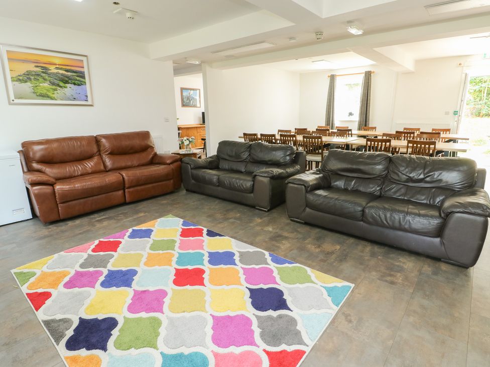 A living room with sofas and a colorful rug at The Bevan in Bontnewydd, Gwynedd
