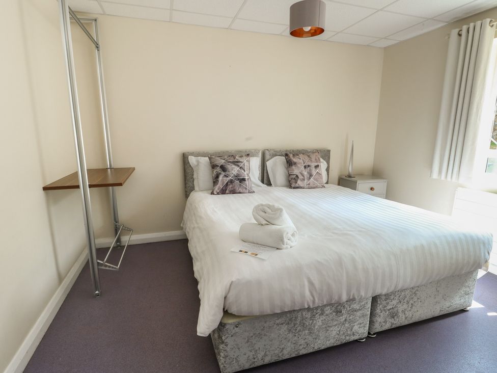A bedroom with a bed and bedside table at The Bevan in Bontnewydd, Gwynedd