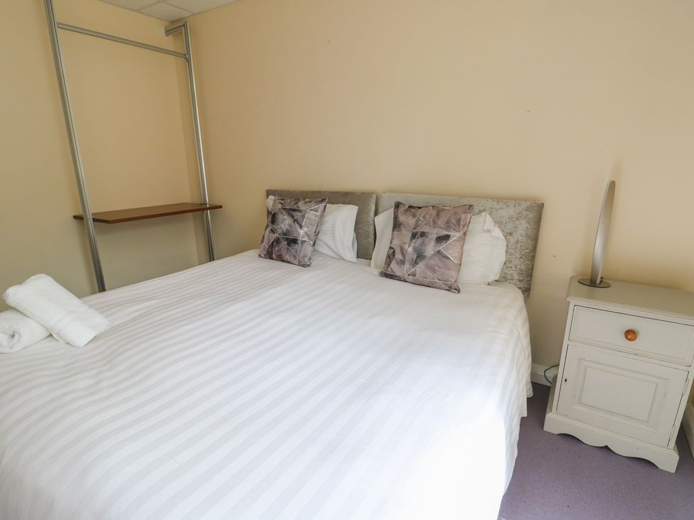 A bedroom with a bed and bedside table at The Bevan in Bontnewydd, Gwynedd