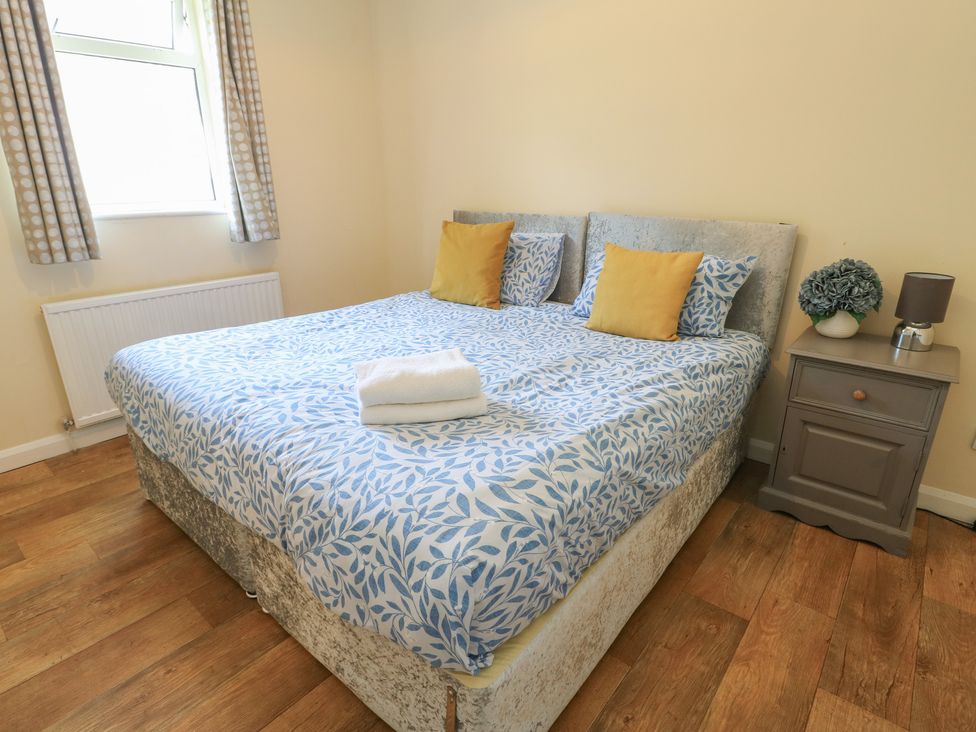 A bedroom with a bed and bedside table at The Bevan in Bontnewydd, Gwynedd