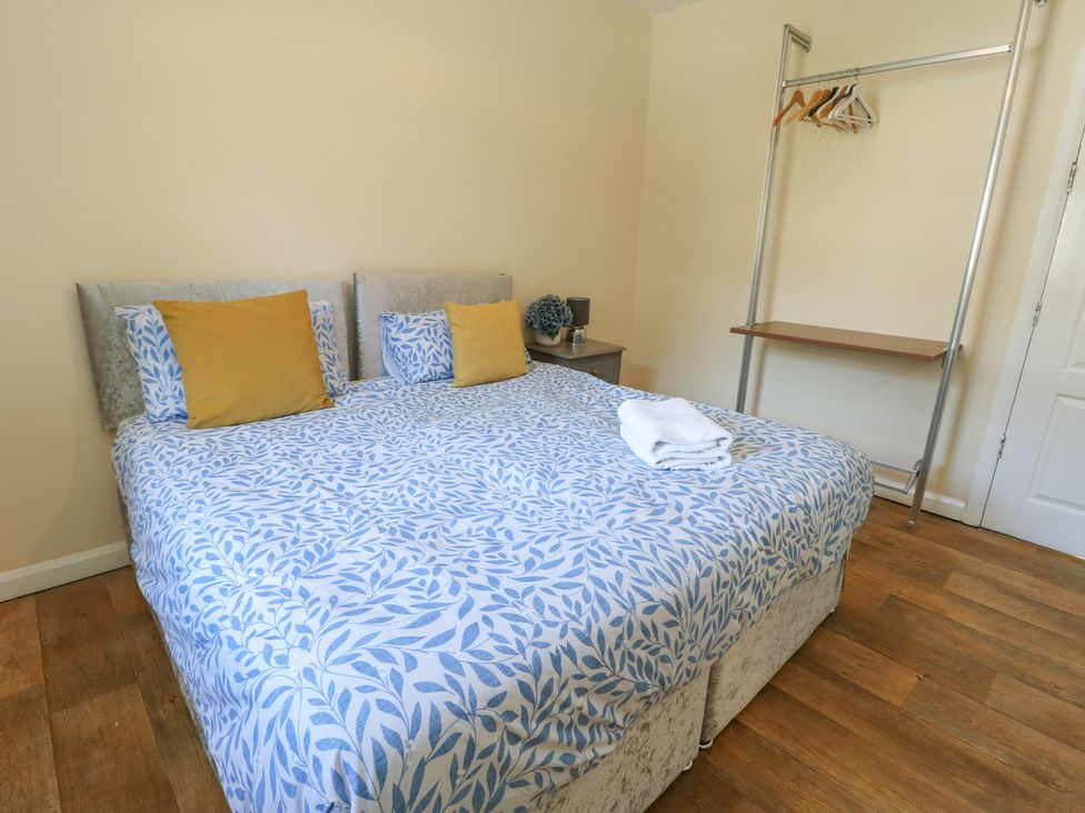 A bedroom with a bed and a clothes hanger at The Bevan, Bontnewydd, Gwynedd