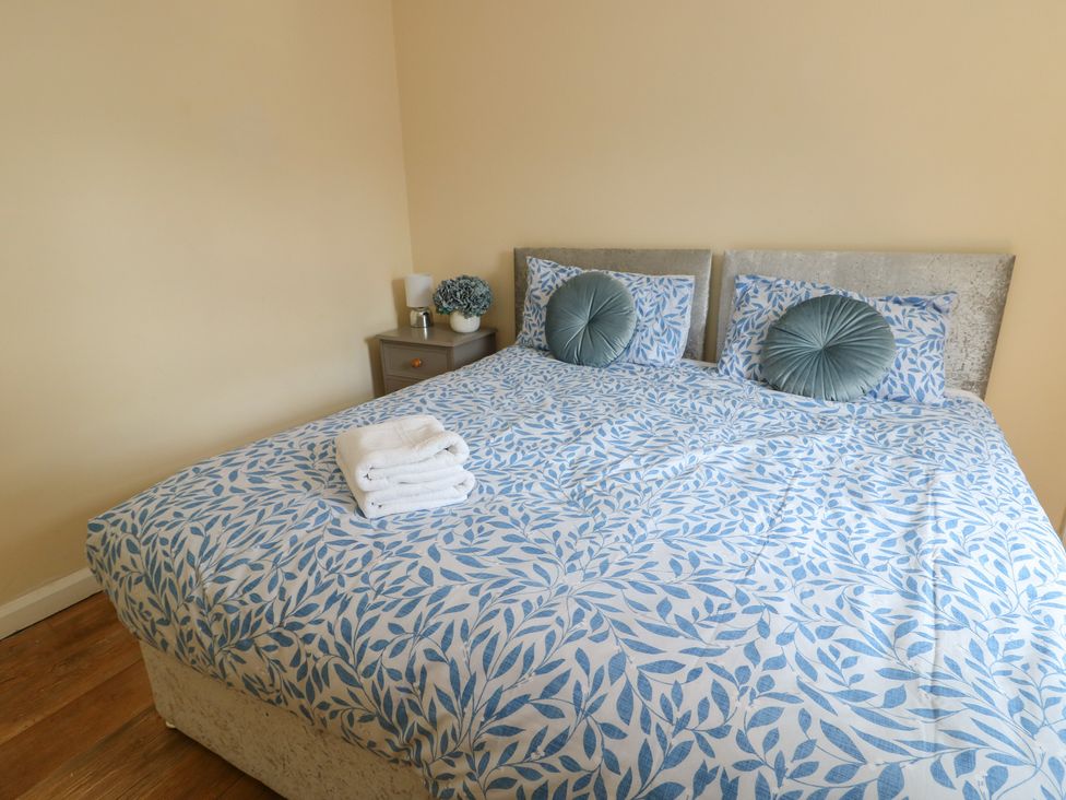 A bedroom with a bed and bedside table at The Bevan in Bontnewydd, Gwynedd